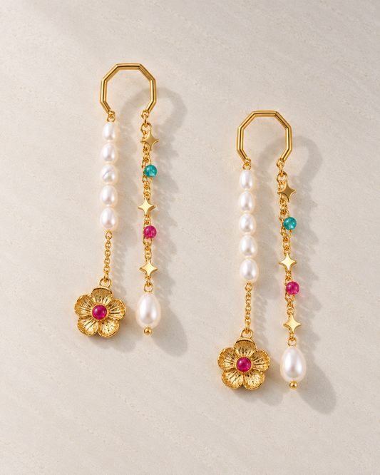 Pendientes Odile con perlas y flor dorada sobre cemento blanco